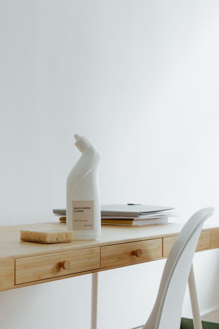 about-04 A clean and organized home office desk with a cleaner bottle and sponge, emphasizing simplicity and functionality.