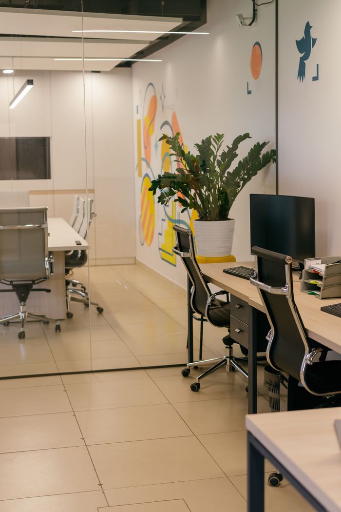 project-01-b Spacious and contemporary office interior with glass partitions, stylish furniture, and vibrant wall art.